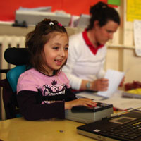 Ayesha using a trackerball to access a laptop computer