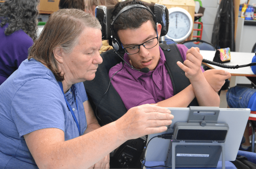 Student in a wheelchair with a teaching assistant