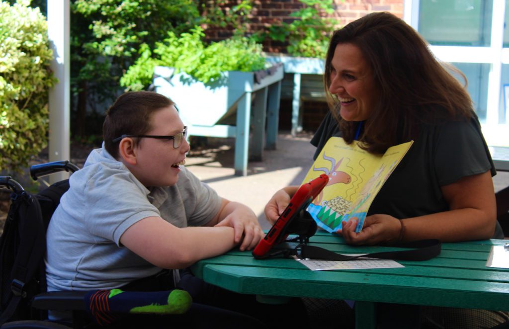 Tina supporting a student using an AAC device.