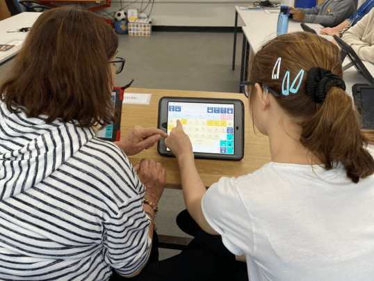 Teacher supporting student with assistive technology