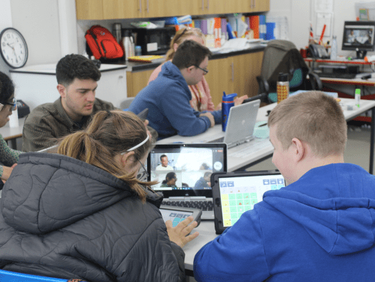 Specialist Teaching Assistant James Dewar-Hassan supporting students in an AAC class.