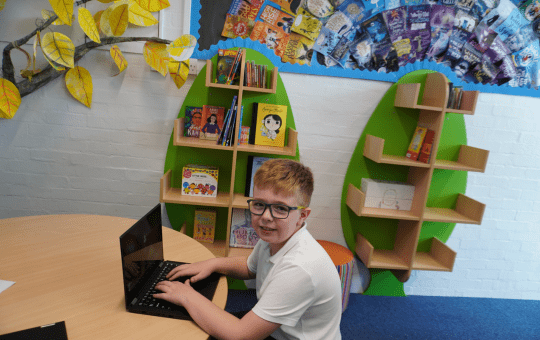 Primary school pupil using his laptop