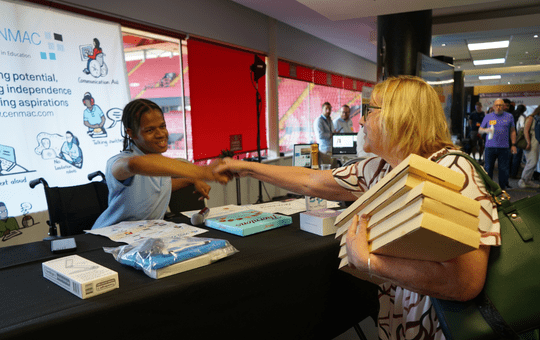 Khamani shaking hands with a raffle prize winner