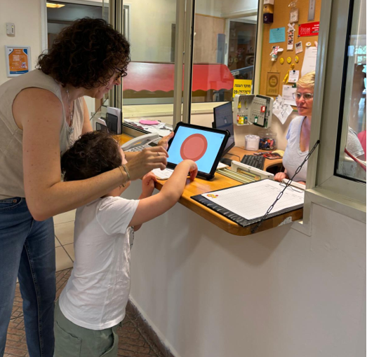 Child using an Issie App to support communication at school reception